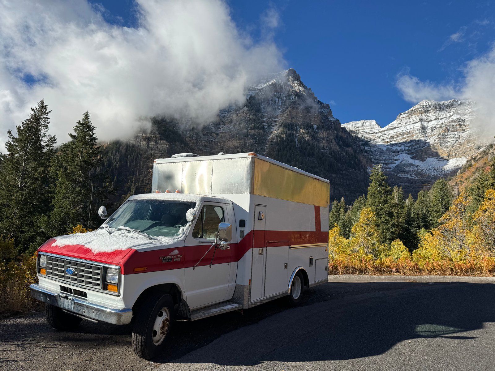1990 Ford E350 ambulance parked outside in the mountains